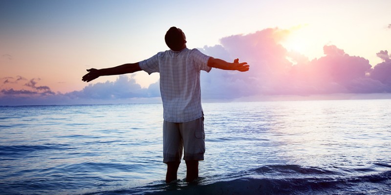 happy young man in sea and sunrise